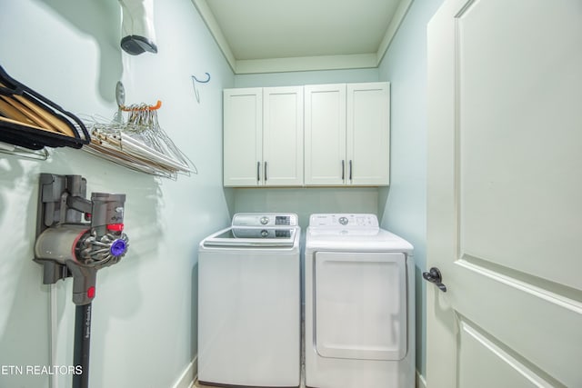 washroom featuring cabinet space and washer and clothes dryer