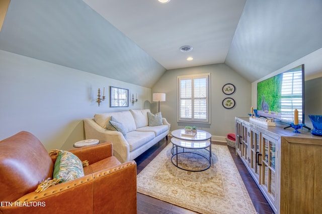 living area with dark wood-style flooring, visible vents, vaulted ceiling, and baseboards