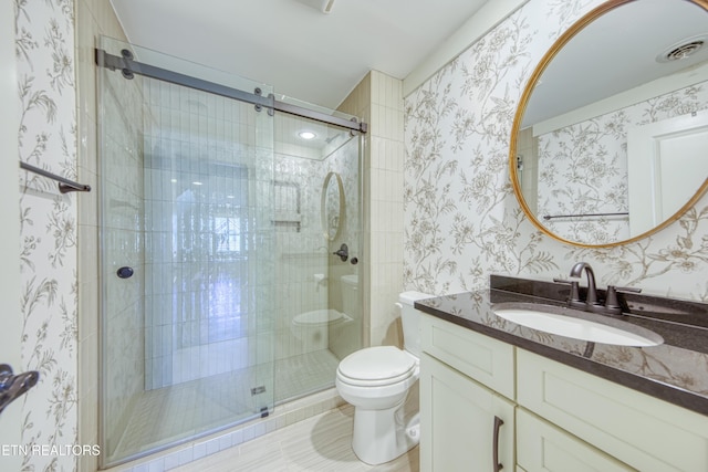 full bathroom featuring vanity, a shower stall, toilet, and wallpapered walls