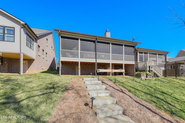 back of house featuring stairs, a yard, a chimney, and a sunroom