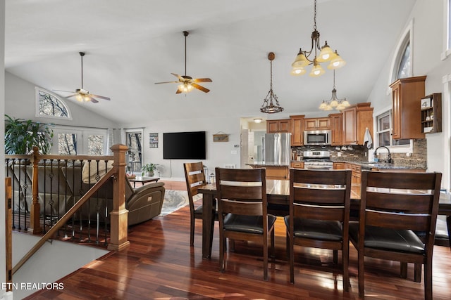 kitchen featuring stainless steel appliances, open floor plan, brown cabinets, dark wood-style floors, and pendant lighting