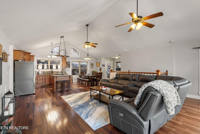 living room featuring dark wood-style floors, high vaulted ceiling, and ceiling fan with notable chandelier