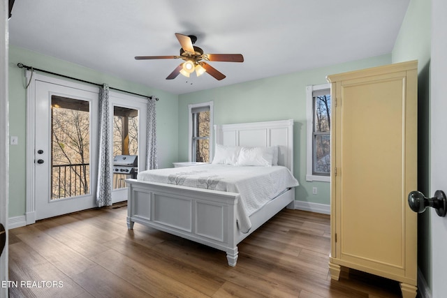 bedroom featuring access to exterior, ceiling fan, wood finished floors, and baseboards