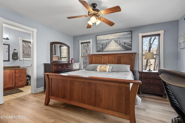 bedroom featuring light wood-style flooring, baseboards, ceiling fan, and ensuite bathroom