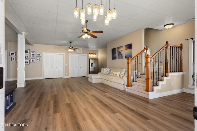 interior space with decorative columns, stairs, visible vents, and wood finished floors