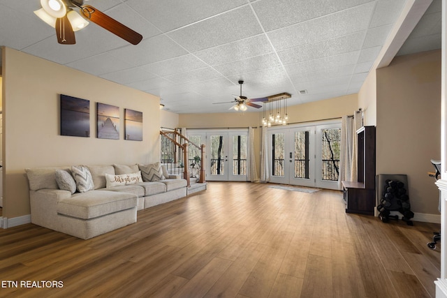 living area with a healthy amount of sunlight, a paneled ceiling, wood finished floors, and french doors