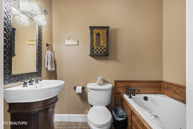 full bathroom with tile patterned flooring, toilet, vanity, baseboards, and a tub with jets