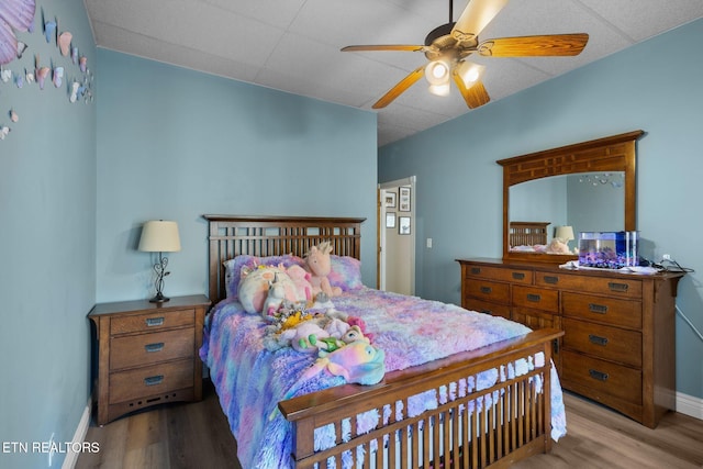 bedroom featuring ceiling fan, wood finished floors, and baseboards