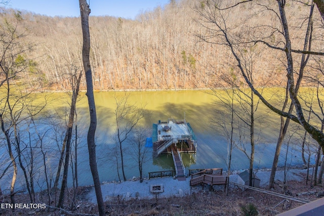 view of dock with a forest view and a water view