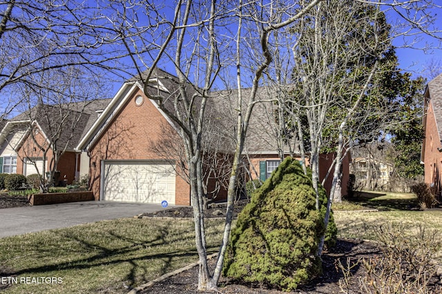 view of front of home featuring a garage, aphalt driveway, and brick siding