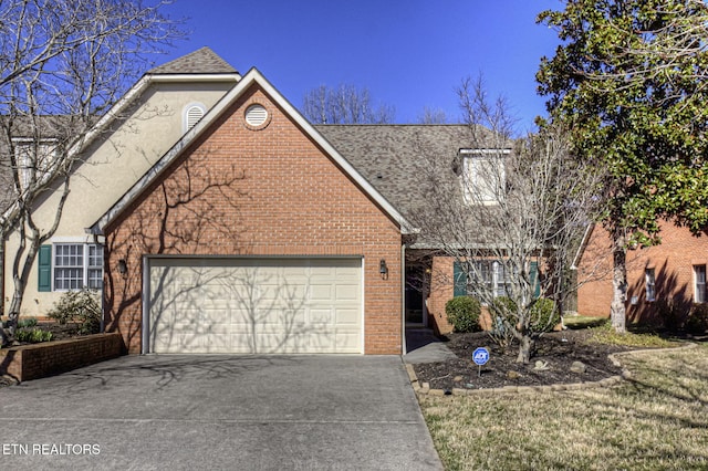 view of front of home featuring driveway, roof with shingles, a garage, and brick siding