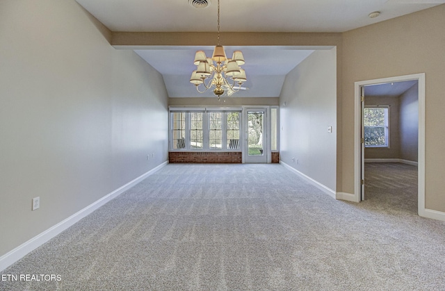 empty room featuring carpet, plenty of natural light, baseboards, and a chandelier