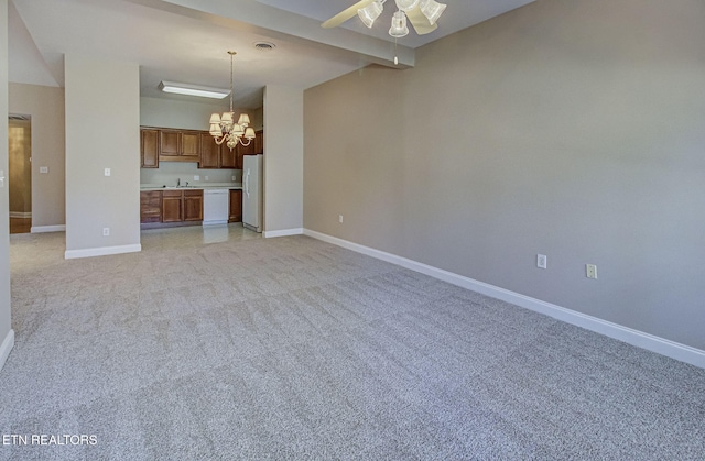 unfurnished living room with visible vents, baseboards, light colored carpet, beam ceiling, and ceiling fan with notable chandelier