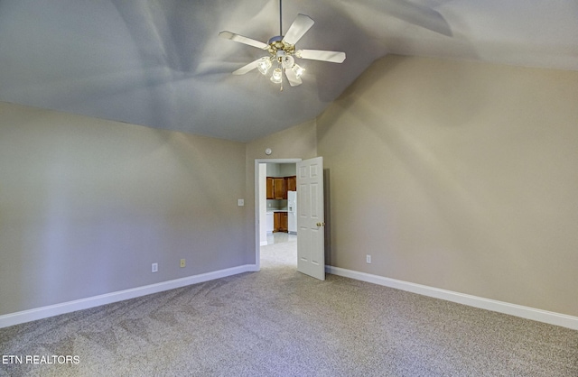 unfurnished bedroom featuring a ceiling fan, light carpet, vaulted ceiling, and baseboards