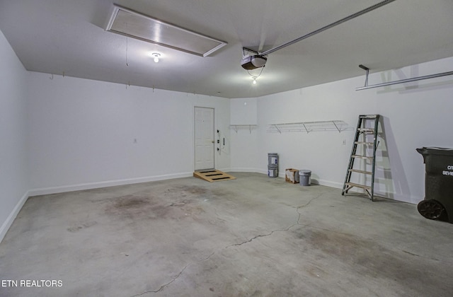 garage featuring a garage door opener and baseboards