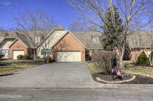 view of front facade featuring driveway, a garage, and brick siding