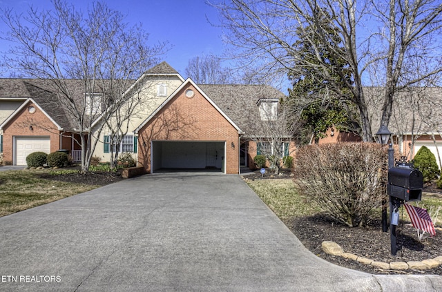 traditional-style house with brick siding, driveway, and an attached garage