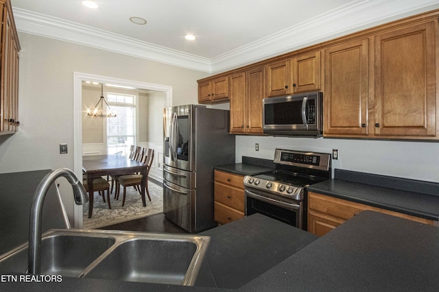 kitchen with dark countertops, appliances with stainless steel finishes, brown cabinets, and a sink