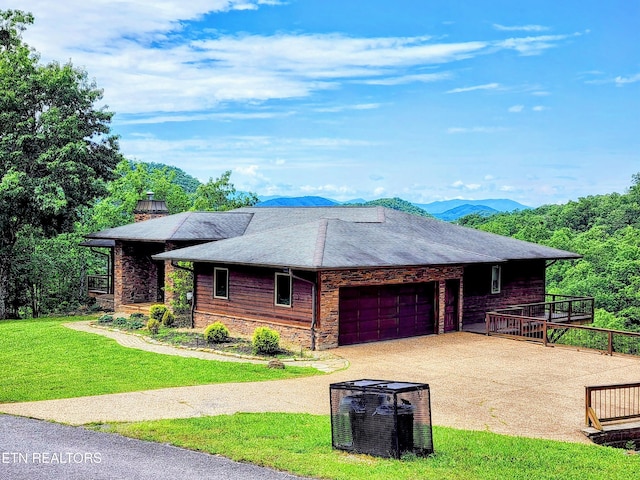 view of front of house featuring a garage, driveway, a chimney, and a front lawn