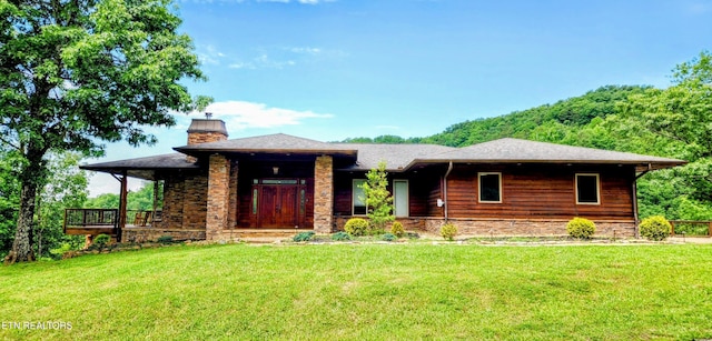 view of front of home featuring a chimney and a front yard