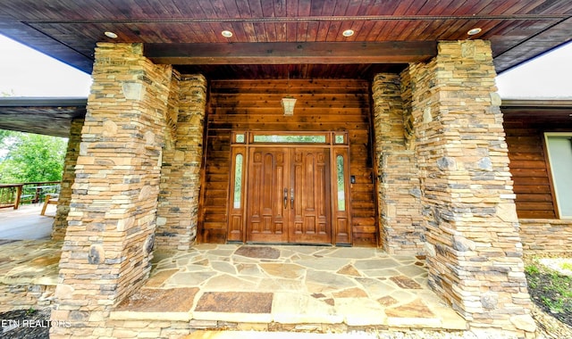 doorway to property featuring stone siding