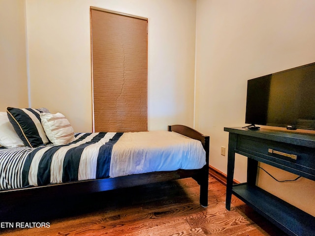 bedroom with baseboards and wood finished floors