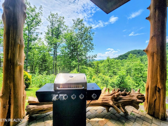 view of patio featuring grilling area and a wooded view