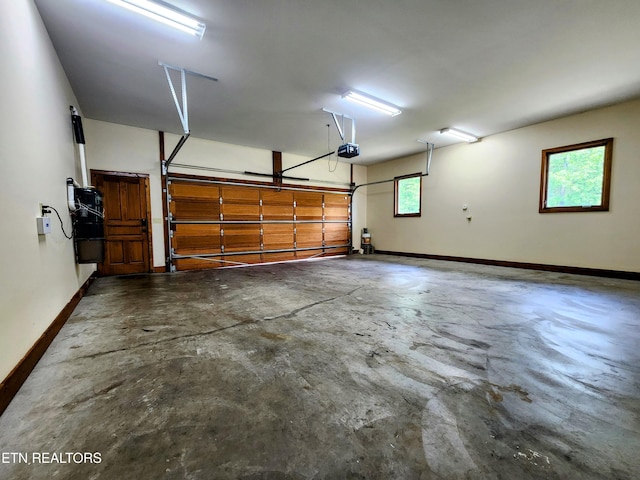 garage with baseboards and a garage door opener