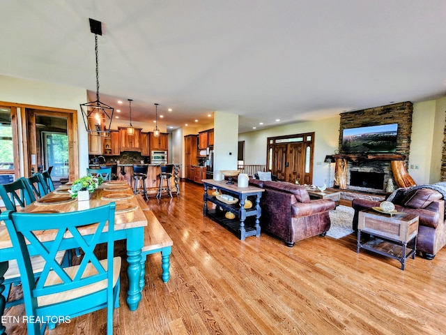 living room with light wood-type flooring, a fireplace, and recessed lighting