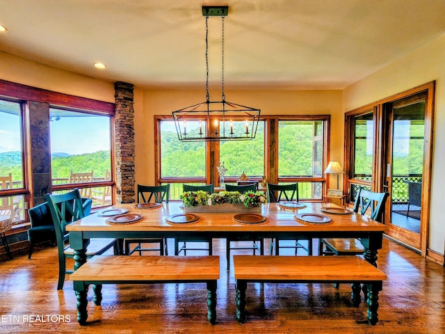 dining room with a wealth of natural light, an inviting chandelier, recessed lighting, and wood finished floors