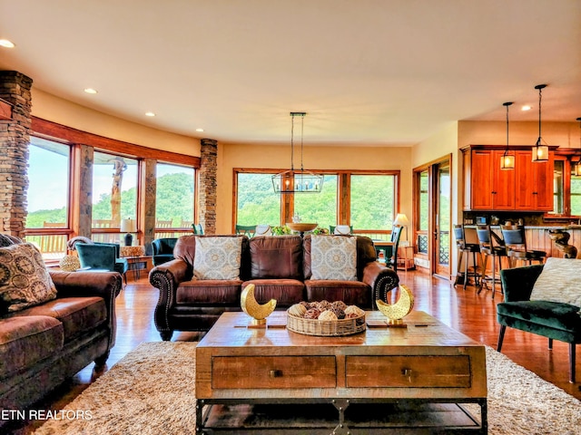 living area with baseboards, wood finished floors, and recessed lighting