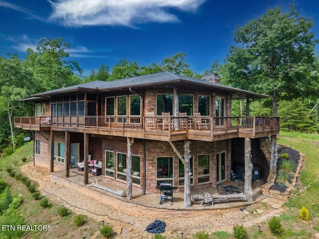 back of house with a patio area, a fire pit, and a wooden deck