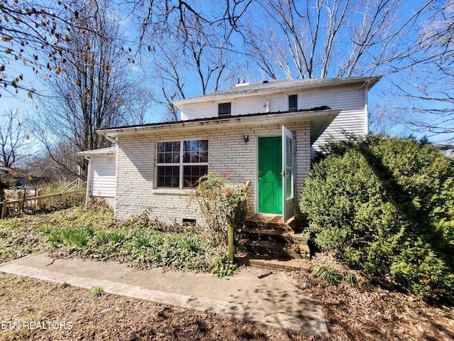 bungalow-style home featuring entry steps, fence, and brick siding