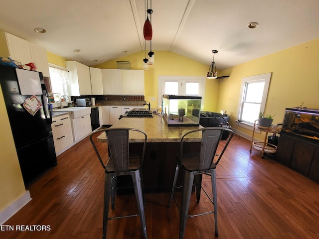 kitchen featuring vaulted ceiling, black appliances, dark wood-type flooring, and white cabinets