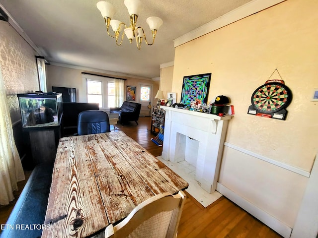 dining space featuring a chandelier, ornamental molding, and wood finished floors