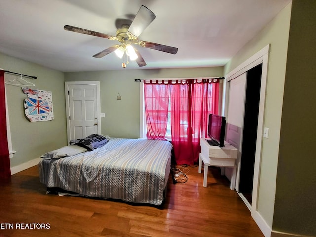 bedroom with ceiling fan, baseboards, and wood finished floors