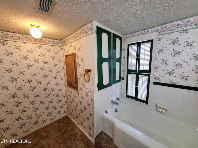 bathroom with wallpapered walls, baseboards, visible vents, a garden tub, and a textured ceiling