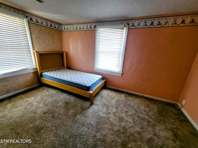 unfurnished bedroom with carpet floors and baseboards