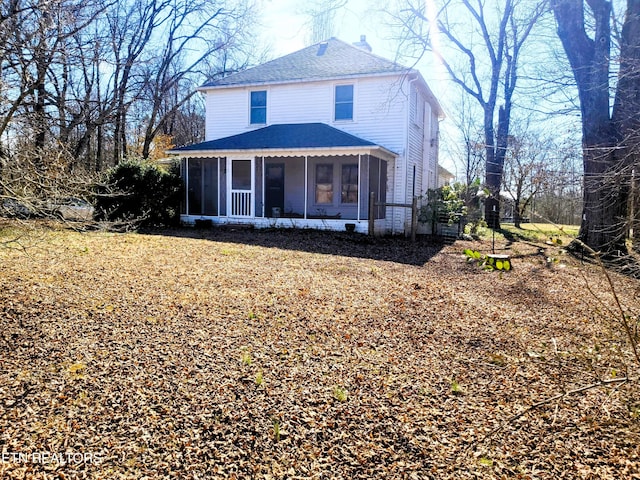 view of front of home featuring a sunroom, a shingled roof, and a chimney