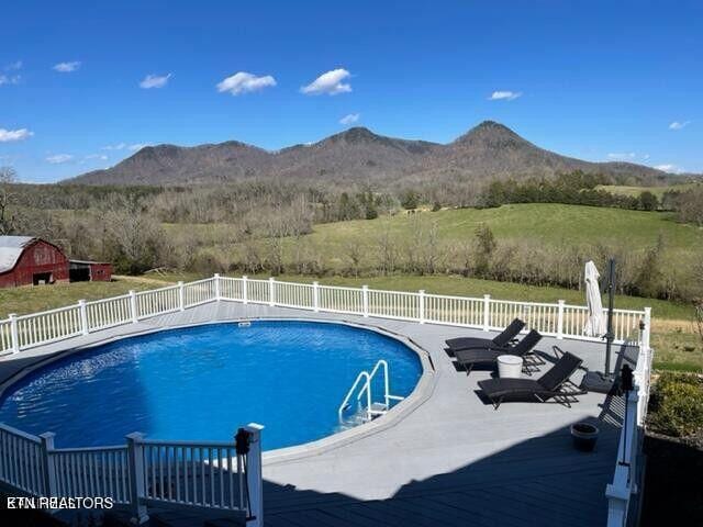 view of swimming pool with a patio area, fence, a mountain view, and a fenced in pool