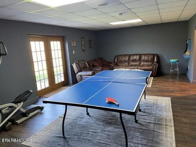 game room with baseboards, a drop ceiling, wood finished floors, and french doors