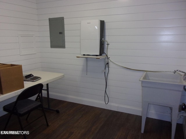 office featuring dark wood-style flooring, electric panel, a sink, and baseboards