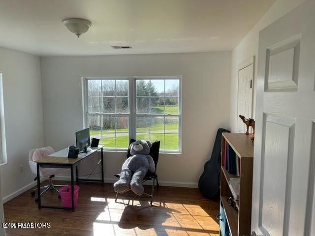 office featuring baseboards, visible vents, and wood finished floors