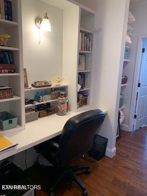 office with baseboards, built in features, and wood finished floors