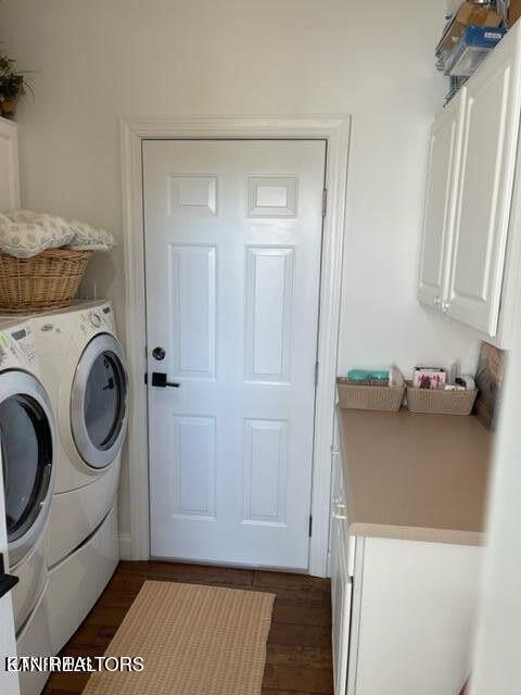 washroom featuring dark wood-style floors, cabinet space, and washer and dryer