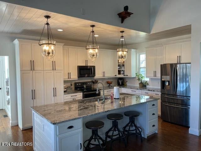 kitchen featuring electric range, dark wood-type flooring, refrigerator with ice dispenser, and white cabinetry