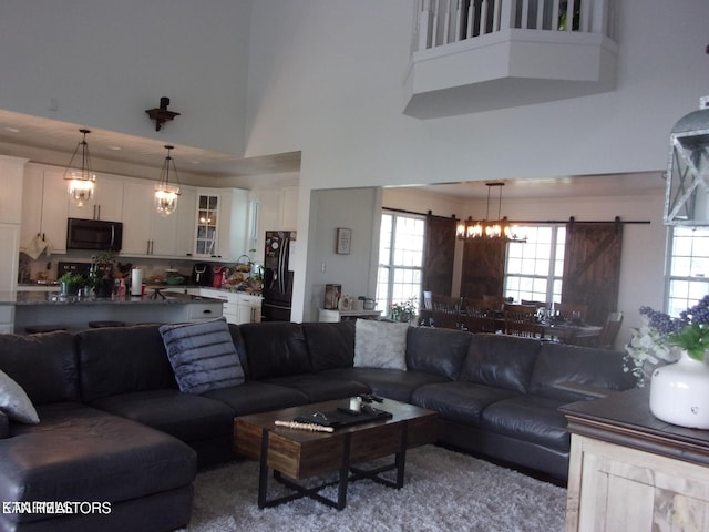 living area featuring a towering ceiling and a barn door