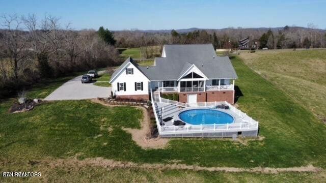 outdoor pool with a yard and stairway