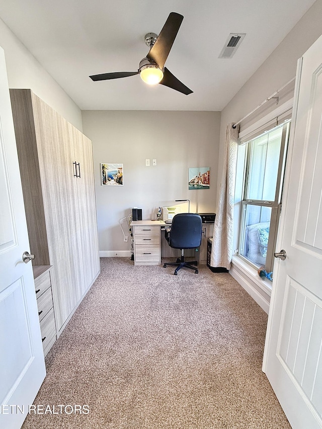 carpeted office with a ceiling fan, visible vents, and baseboards