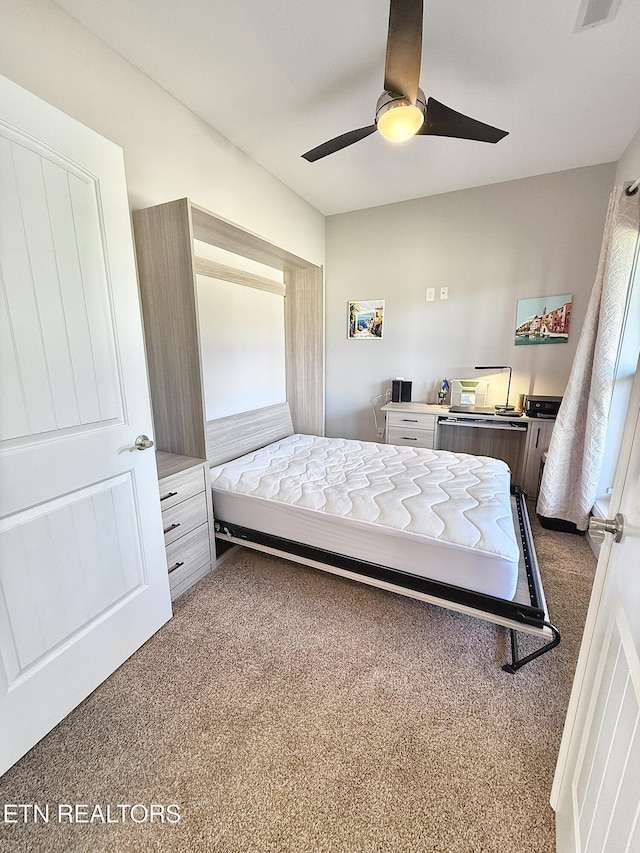 carpeted bedroom featuring a ceiling fan and visible vents